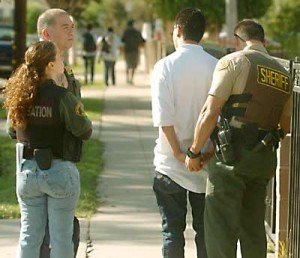 pico_riv Probation officer Julie Longoria, left, with Los Angeles County Sheriff's Sgt. Tony Romo, left center, and Deputy Tom Shultz, right, stop a juvenile tagger on Olympic Blvd. in Pico Rivera who is on probation. The Sheriff's Vandelism Enforcement Team (VET) has been focussing their efforts on graffiti and tagging. (SGVN/Staff Photo by Keith Durflinger)