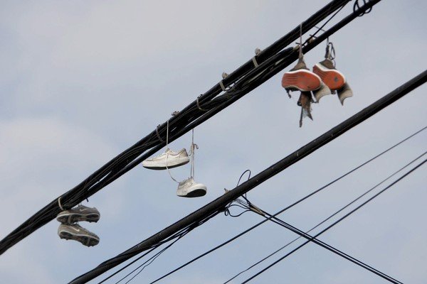 Why You Always See Tennis Shoes on Telephone Lines gang shoes telephone wire